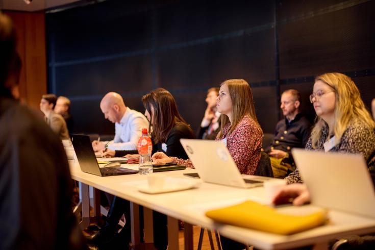 People sitting at a table with laptops in front of them